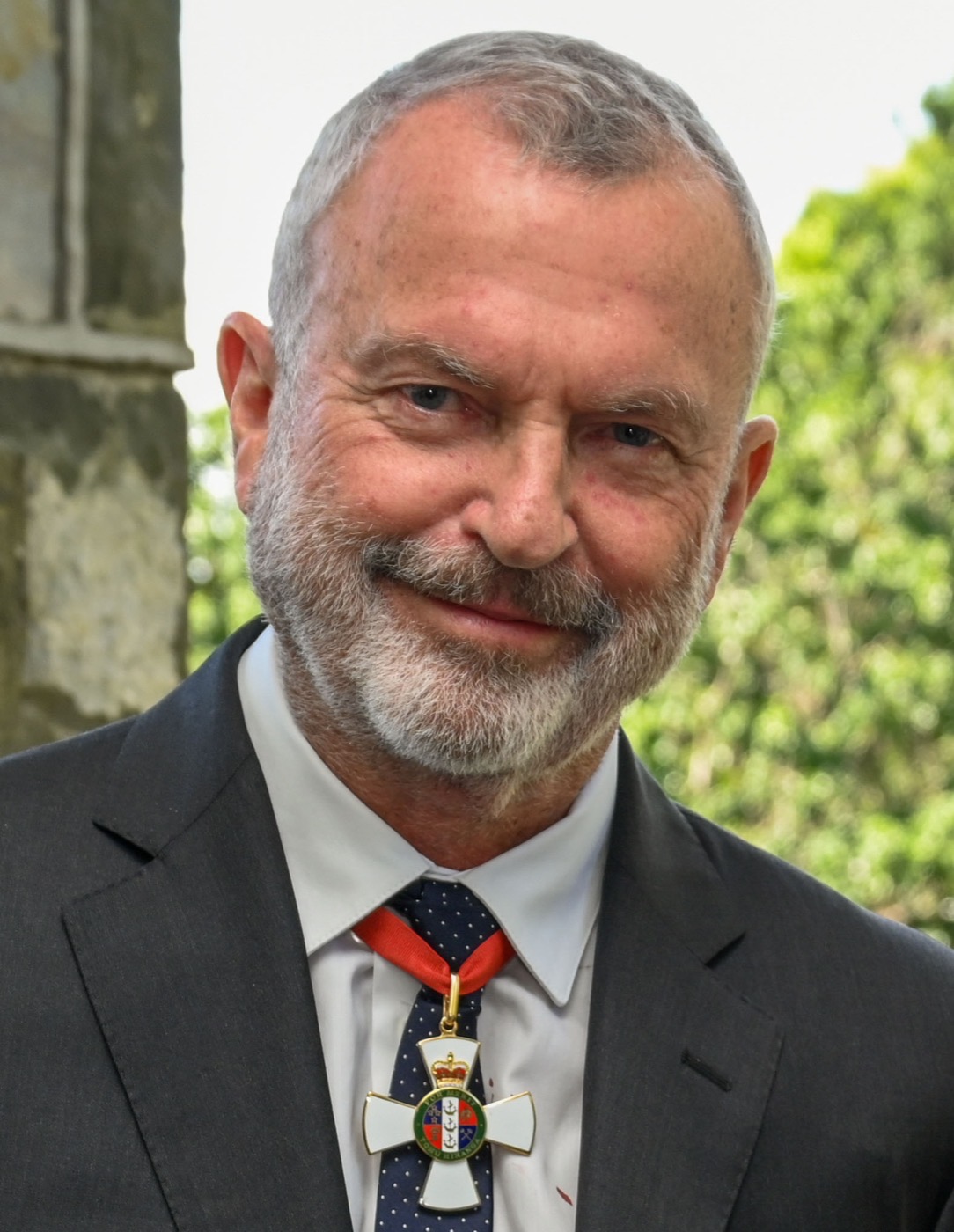 Sam Neill im Anzug, mit dem Kreuz des New Zealand Order of Merit am Band