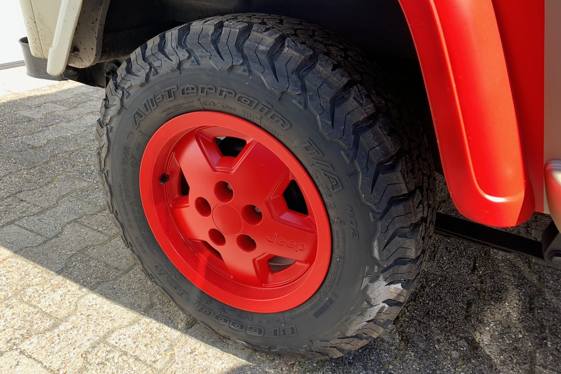 Rotlackierte Felge mit Reifen eines Jeep Wrangler in „Jurassic Park“-Optik