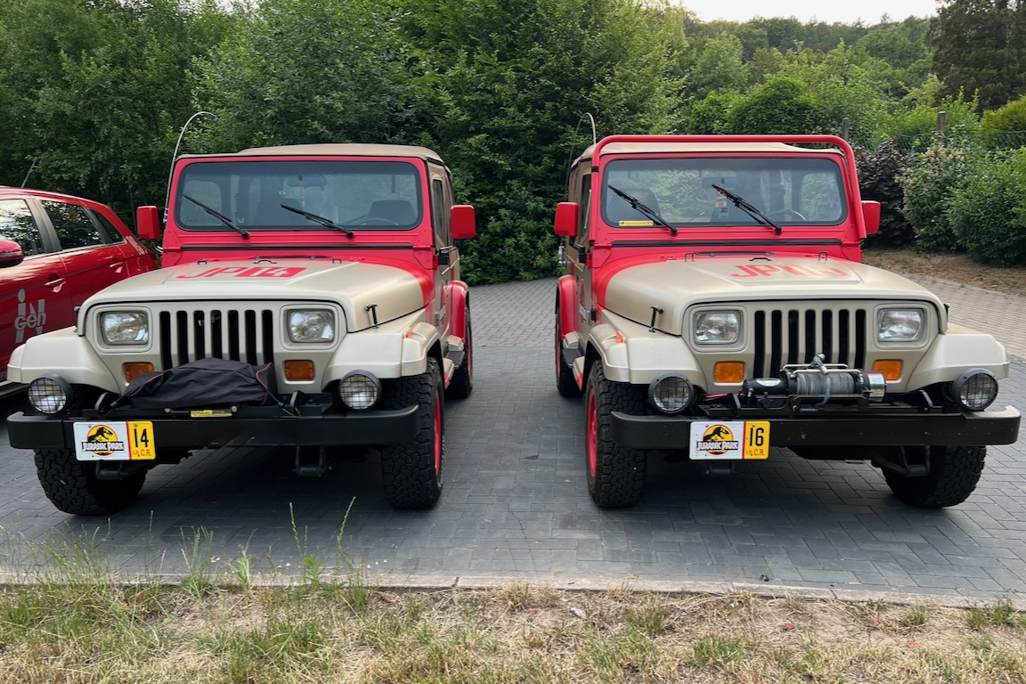 Zwei „Jurassic Park“-Jeeps, davon eine Modellvariante Sahara, auf einem Hotelparkplatz